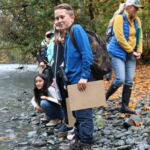 Students observing salmon (on banks in in the water) on the shores of the Duckabush River at Duckabush Oxbow and Wetlands Preserve.
